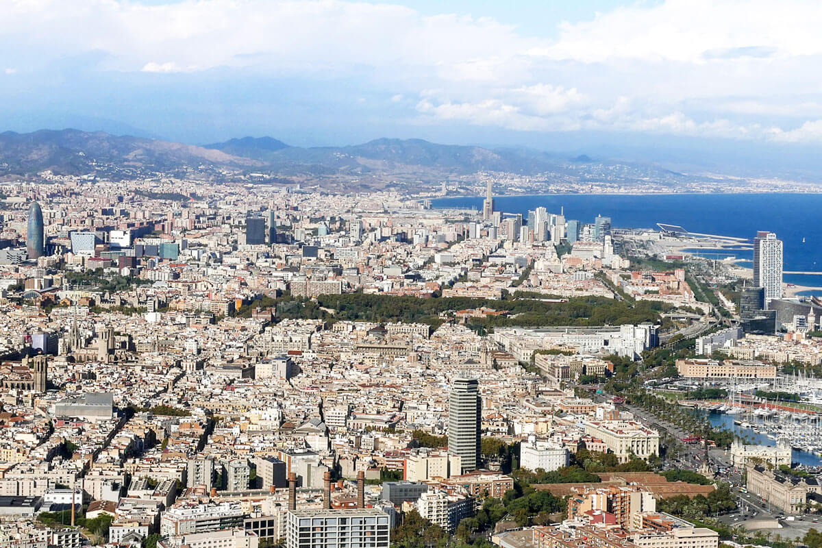 Panoramic view of Barcelona from Montjuïc, surrounded by mountains and the Mediterranean Sea