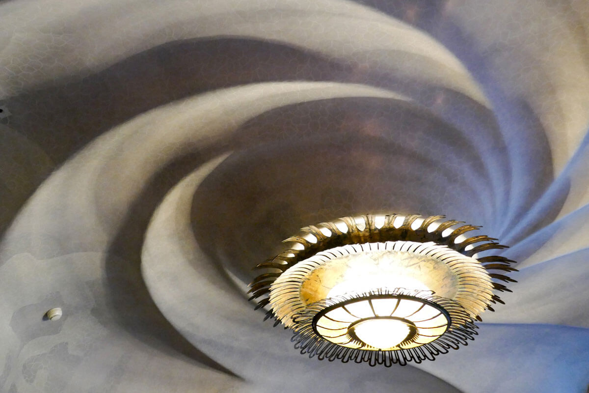 Spiral ceiling with circular art nouveau lamp inside Gaudí's Casa Batlló