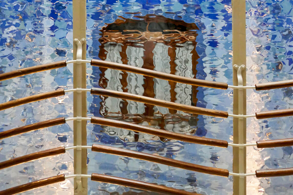View through textured glass into the blue tiled interior courtyard of Gaudí's Casa Batlló
