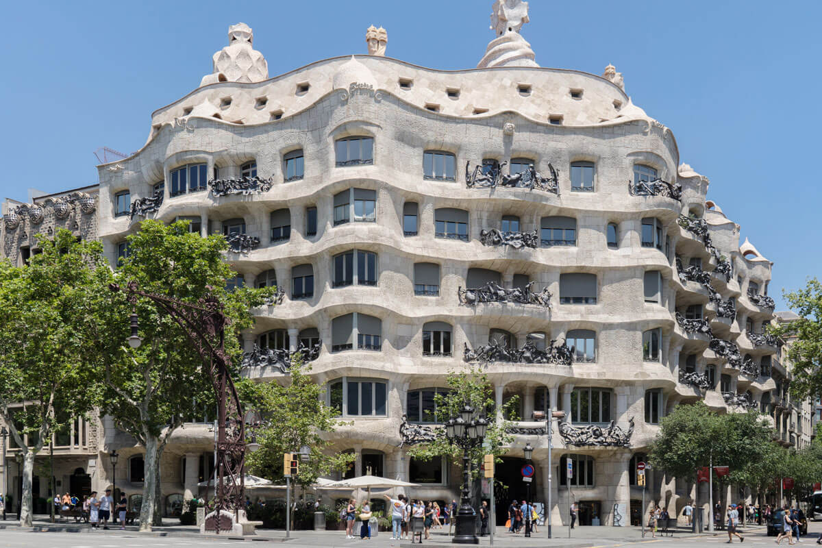 Undulating stone facade facade of Barcelona's Casa Milà , decorated with wrought iron balconies