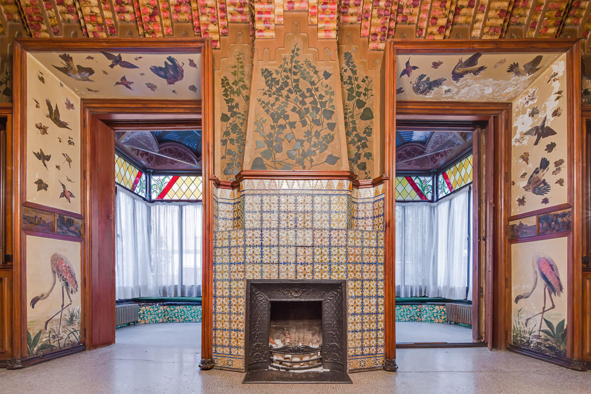 Fireplace an wall decoration of the Casa Vicens' dining room with climbing ivy and birds in flight