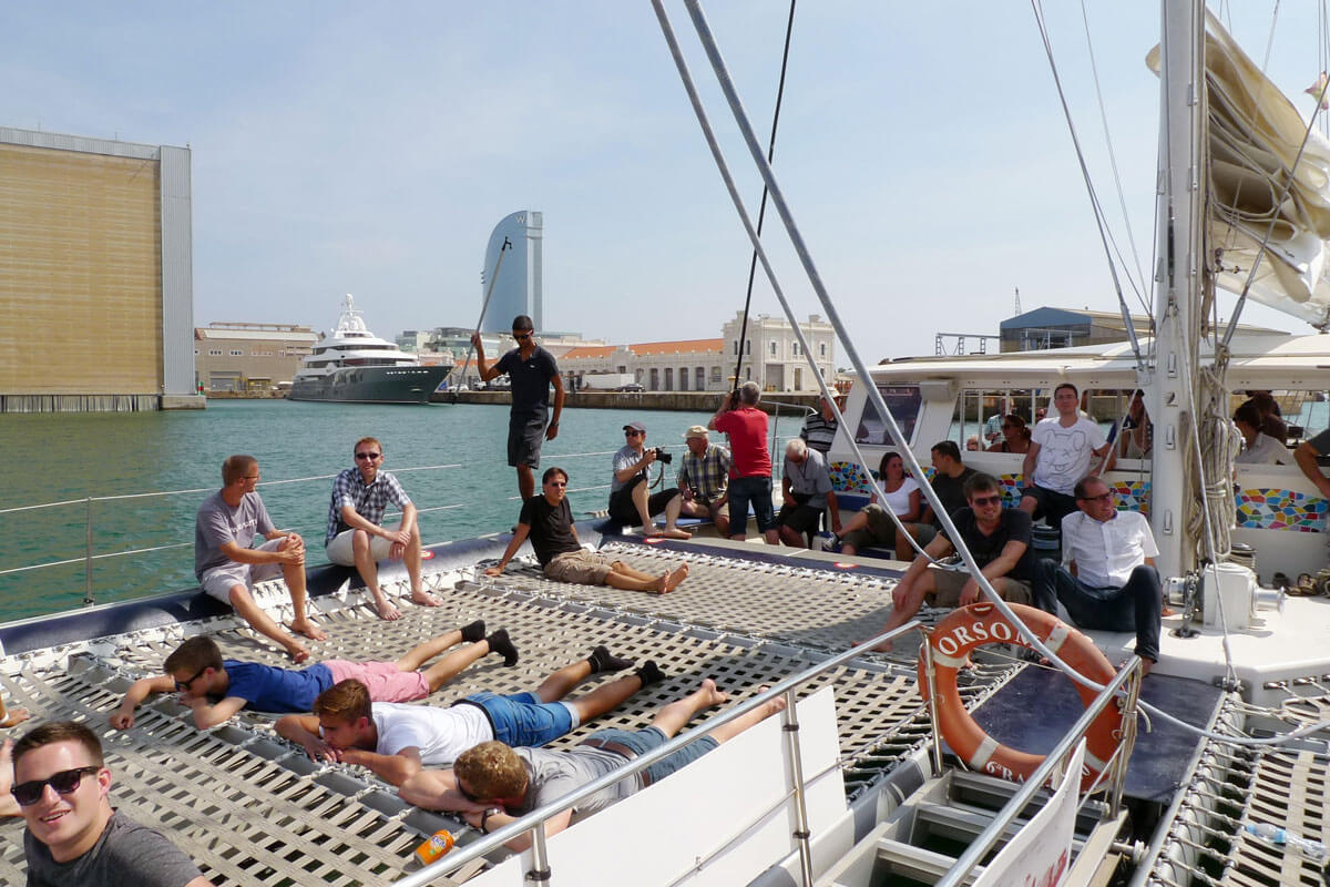 Group of architects enjoying a private catamaran sailing trip off the coast of Barcelona