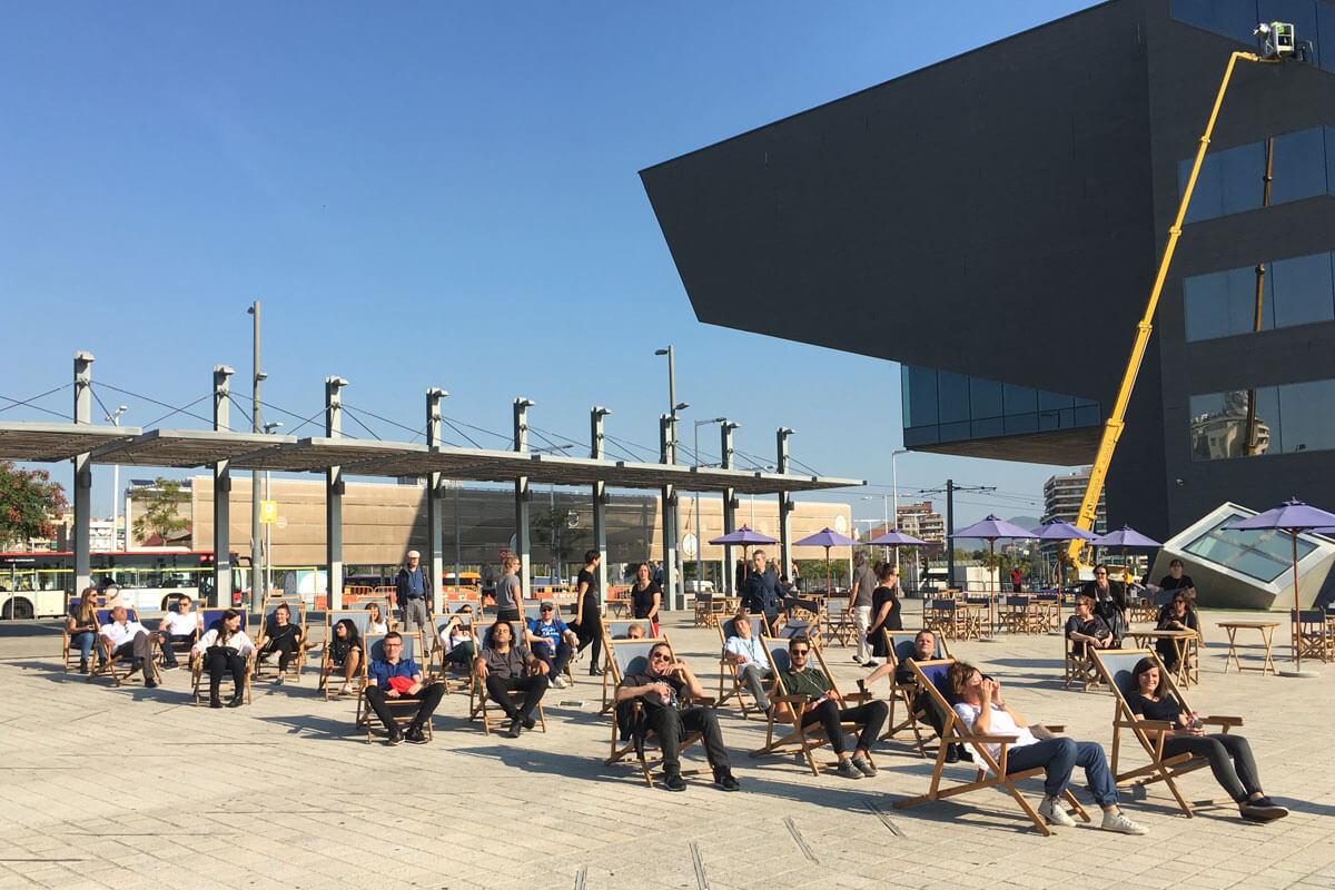 Group of architects relaxing in deck chairs in front of Barcelona's Museu del Disseny