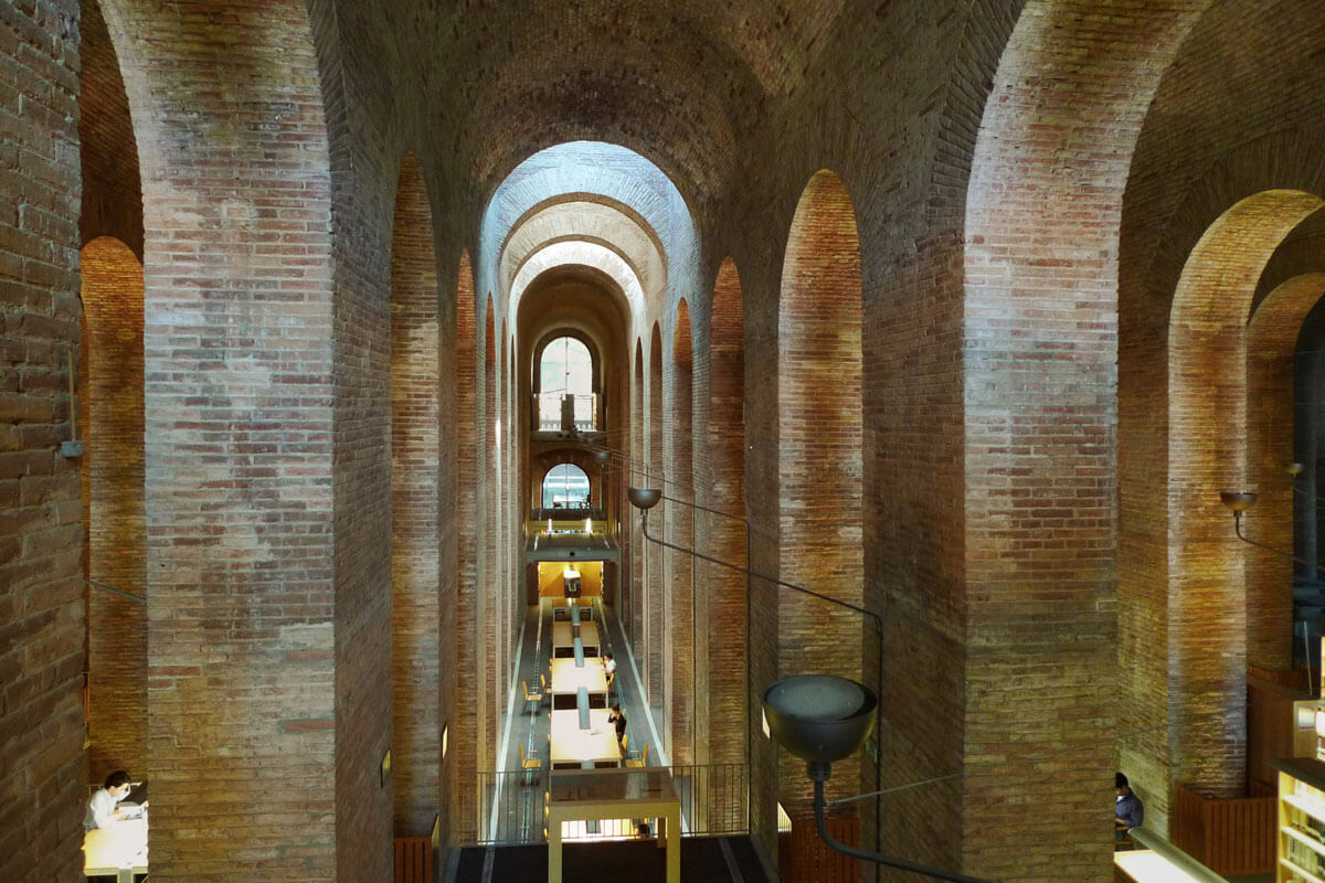 Interior of an old water deposit turned into university library, featuring a maze of tall masonry arches