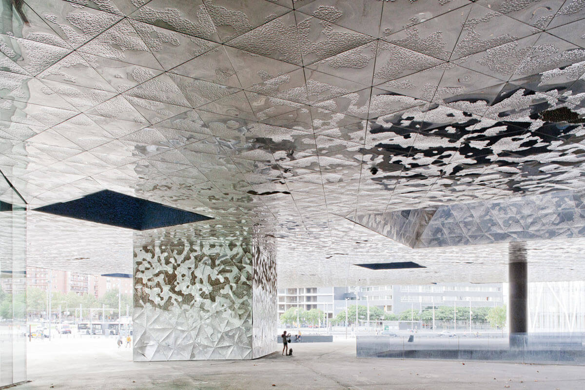 Public space beneath Barcelona's Forum building, whose underside of embossed metal panels evokes the surface ot the sea