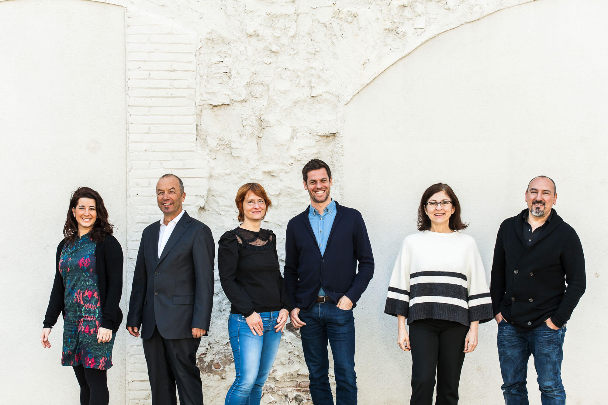 Expert team for architectural tours in Barcelona, posing in front of white building facade