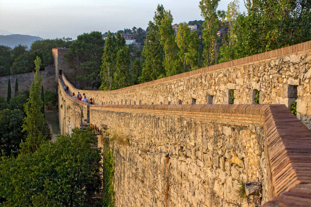 Walkway along Girona's old city walls with towers and scenic views of the surroundings