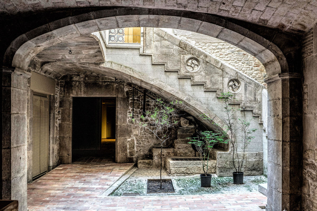 Inner courtyard and main staircase of well-preserved medieval building in Girona's Jewish Quarter