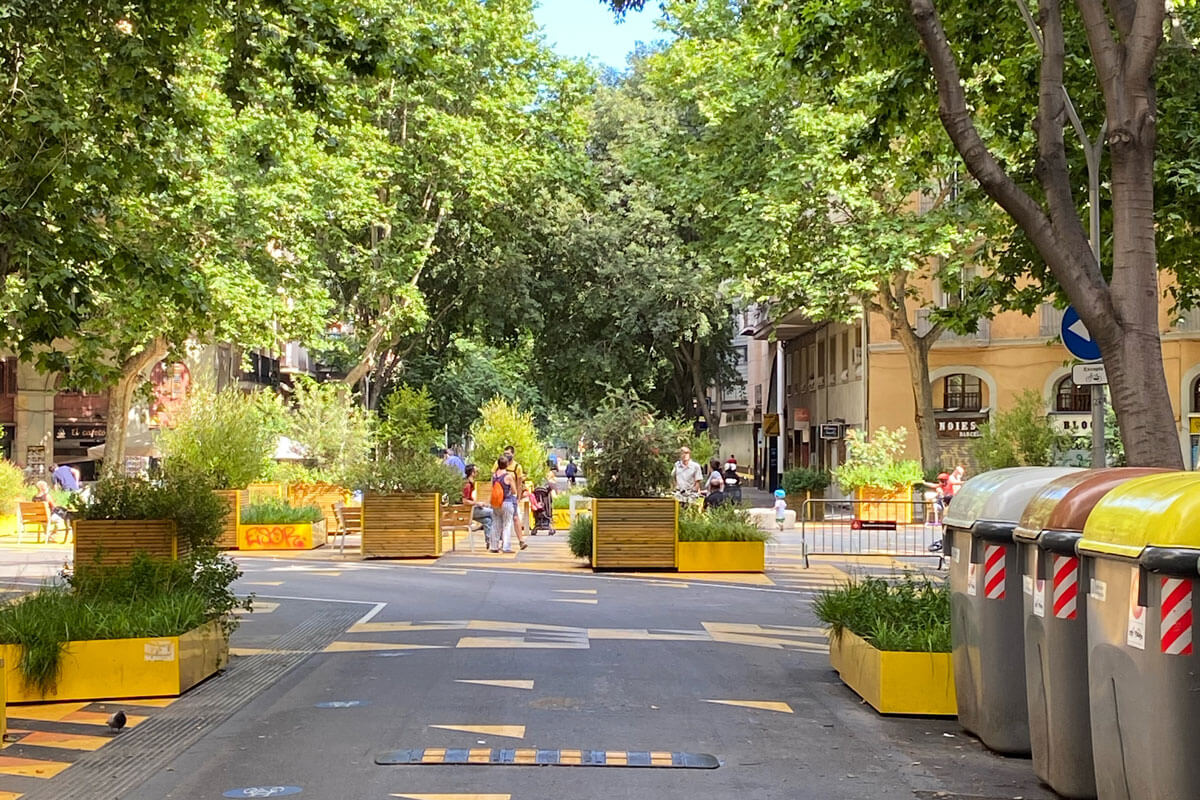 Eixample road junction turned green space with yellow street paint and temporary urban furniture