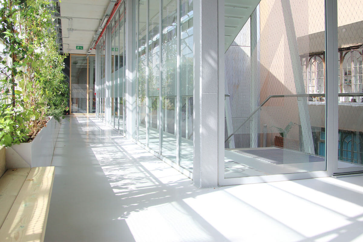 Inner circulation space of a community center, accompanied by a living green wall