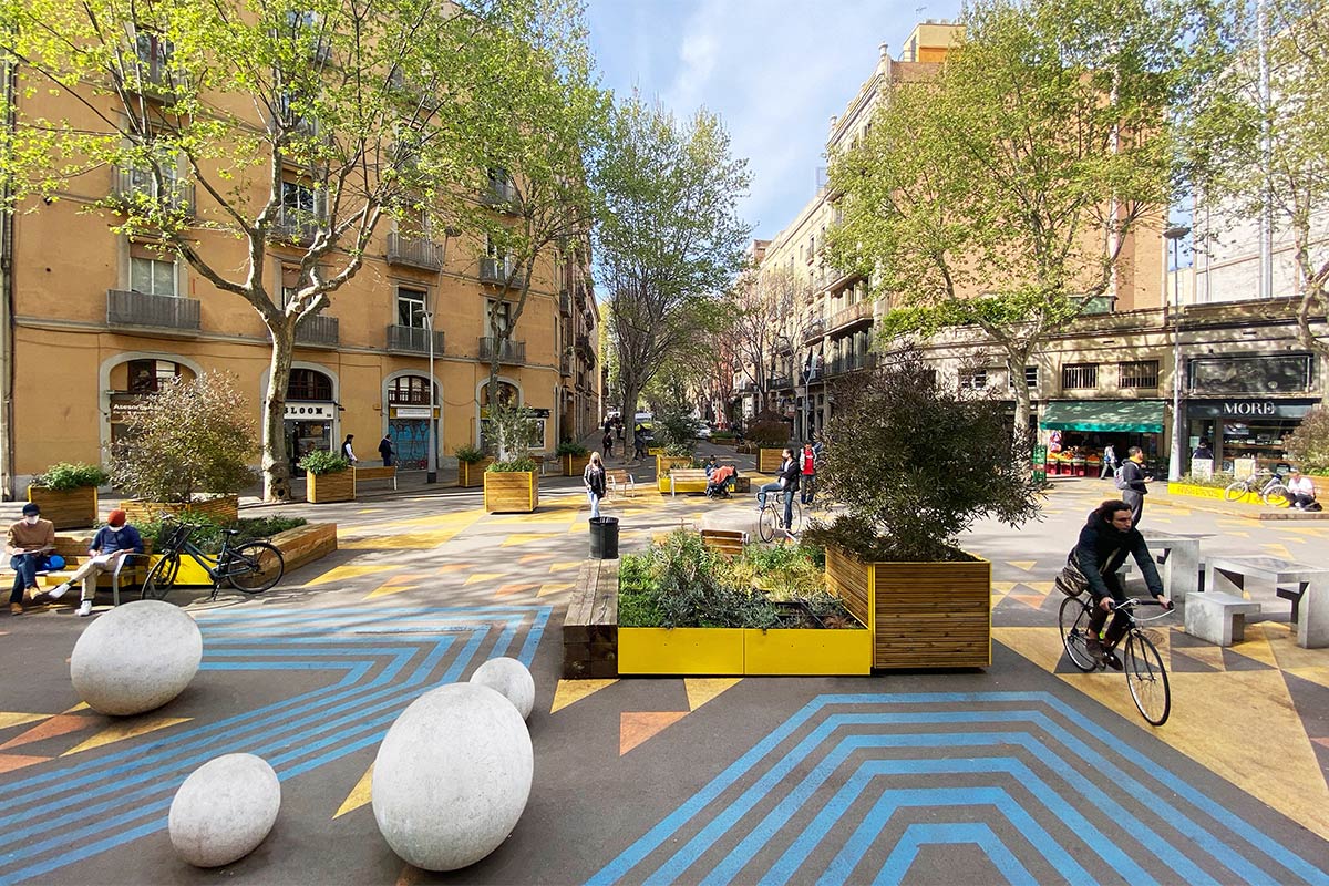 Eixample road junction turned green space with yellow street paint and temporary urban furniture